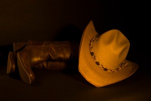 Still life photograph of cowboy hat and boots
