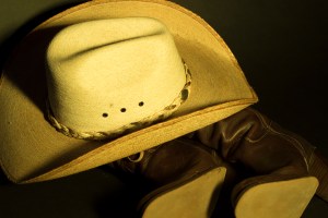 Still life photograph of cowboy hat and boots