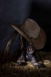 Colour still life photograph of brown cowboy boots and hat